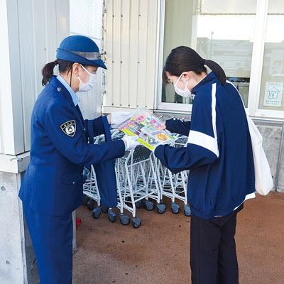 写真：夕暮れ時の交通安全啓発でグッズを配る関係者