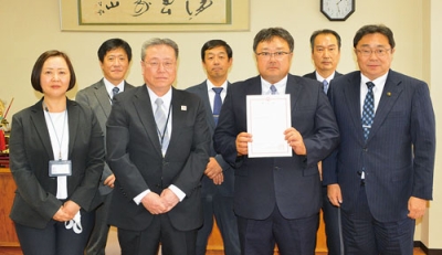 写真：小笠原市長（前列右端）から市教委委員の辞令を交付された上村さん（左隣）