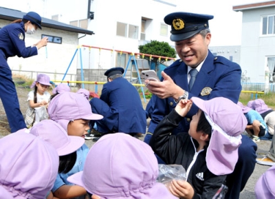 写真：ヒマワリの種を採取する子どもたちの動画を撮影する桑迫係長