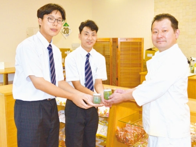写真：久保社長（右）に作成した藍の粉末を手渡す生徒