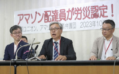 写真：アマゾンの商品配達中に負傷して労災認定を受け、記者会見する個人事業主の男性（中央）＝４日午後、厚労省