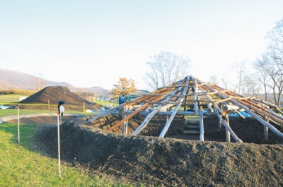 写真：修復作業が進む入江貝塚公園の竪穴式住居２基