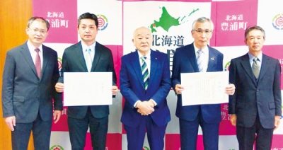 写真：町から感謝状を受け取った鈴木社長（右から２人目）と正木代表取締役（同４人目）