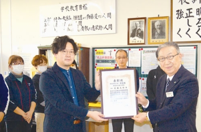 写真：準特選の賞状を受け取る西島教諭（左）