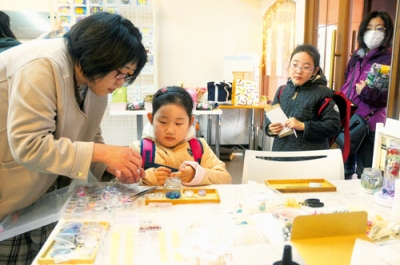 写真：ハーバリウム作りに取り組む来場者ら