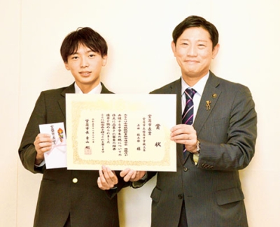 写真：青山市長から賞状を受け取った石田さん（左）