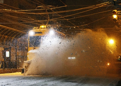 写真：今季初めて出動し、路面電車の軌道に積もった雪を掃き飛ばす「ササラ電車」＝２４日夜、札幌市