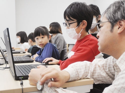 写真：デザインを考えながら年賀状作りに取り組む参加者ら