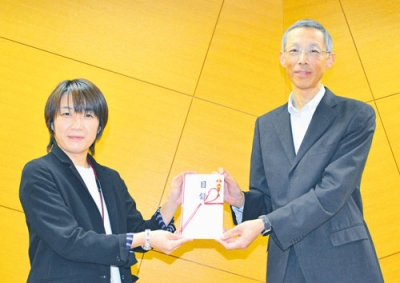写真：頓所事務局長（右）から目録を受け取った湯浅施設長