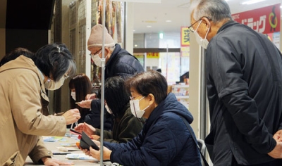 写真：デジタル券をスマホへ取り込む市民
