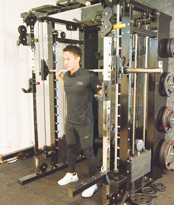 写真：自慢のトレーニング器具で筋トレをする佐々木さん