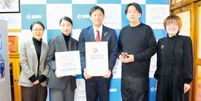 写真：２０２３年度グッドデザイン賞の表彰状を手にする青山市長（中央）と小林代表取締役（右から２人目）