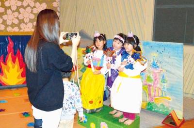 写真：新しい衣装を楽しむ子どもたちと撮影する保護者