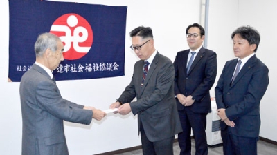 写真：善意を手渡す小杉会長（左から２人目）