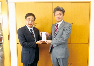 写真：髙木事務局長（左）に寄付金を手渡す本社の長内営業部長