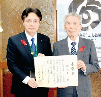 写真：中央共募会長表彰を受賞した田村前会長（右）と大塩町長