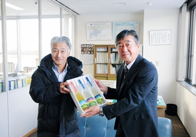 写真：シードルを寄贈する川南委員長（左）