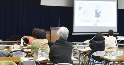 写真：ＤＶＤ視聴を通し転倒や骨折の介護予防体操に取り組む参加者ら