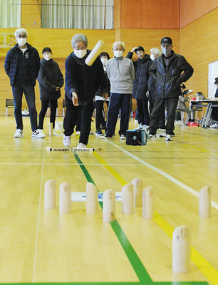 写真：仲間が見守る中、モルックを楽しむ参加者