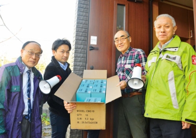 写真：荒関会長（右から２人目）にハンドマイクを配布する市連町スタッフ