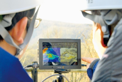 写真：ドローンから送られてくる画像やデータを確認する気象庁の職員