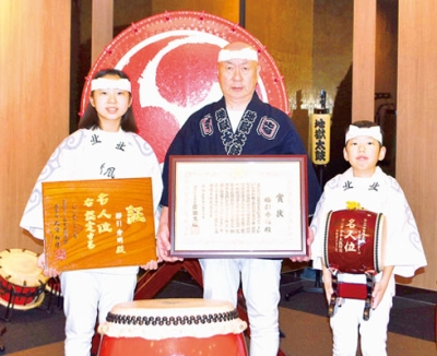 写真：表彰状を手にする櫛引秀明さん（中央）。名人位の盾を手にする杏月さん（左）と大和君