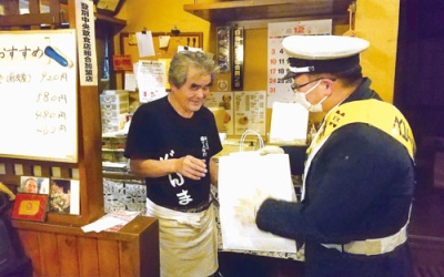 写真：飲食店を訪問し、啓発グッズを手渡す参加者