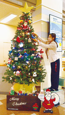 写真：クリスマスツリーを飾り付けする職員