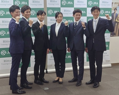写真：新規調教師免許試験に合格し、ポーズをとる前川恭子さん（右から３人目）ら＝７日、栗東トレーニングセンター
