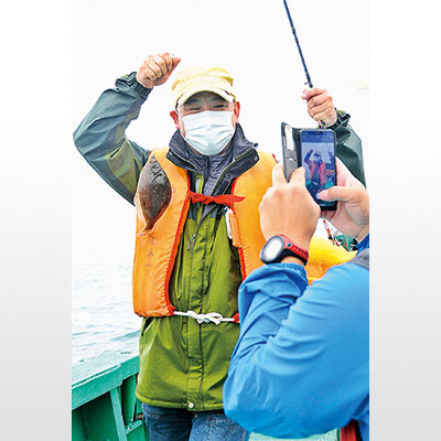 写真：カレイを釣り、満足げな参加者＝２０２１年７月