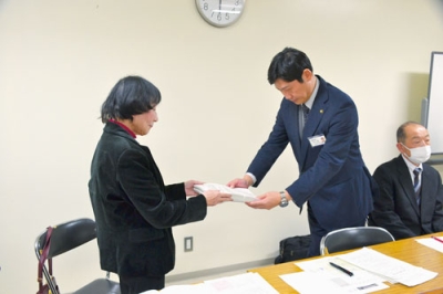 写真：青山市長（右）に大ホール存続を訴える署名を手渡す三村会長