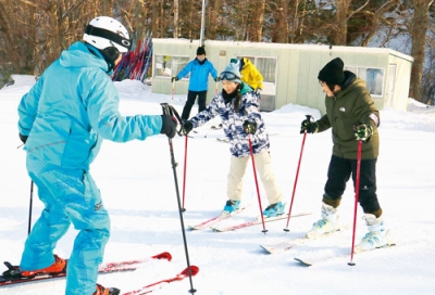 写真：スキーの滑り方を教わる家族