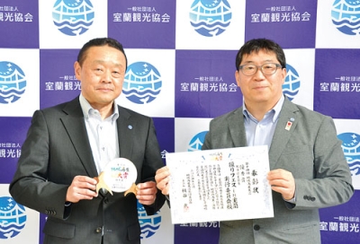 写真：賞状と記念盾を持つ仲嶋事務局長（右）と伊藤専務理事
