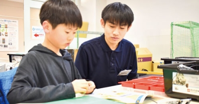 写真：レゴブロックを組み立て、パーツを作る小学生
