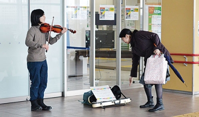 写真：留学を夢見て東室蘭駅自由通路でバイオリンの路上演奏を続ける心呼さん