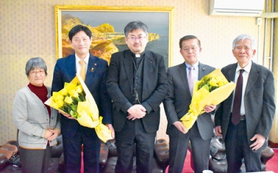写真：蓑島主任司祭（中央）らから「黄金のバラ」の花束が贈られた青山市長（左から２番目）と早川議長（右から２番目）