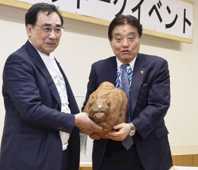 写真：八雲町で開かれたイベントに参加し、木彫り熊を抱える河村たかし名古屋市長（右）＝２６日午後