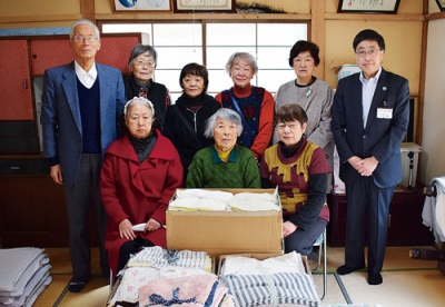 写真：清拭布を寄贈した長生会の会員らと高木事務局長（右）