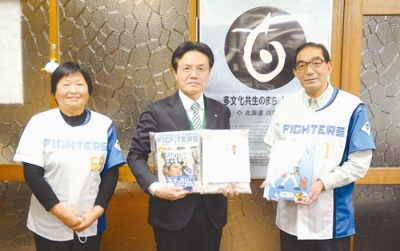 写真：クリアファイルなどを贈った田野島会長（右）と村上相談役（左）