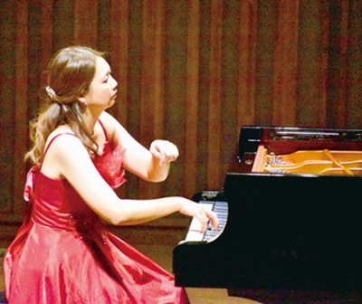 写真：情感を込めピアノを奏でる女性