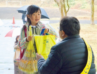 写真：新入学児童に啓発物を手渡す小笠原市長