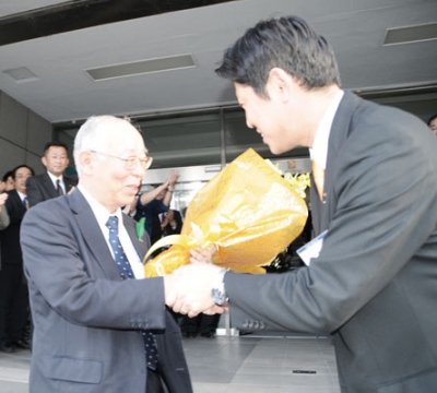 写真：副市長退任日、青山市長と握手する故・寺島孝征氏＝２０１５年５月１１日、室蘭市役所正門前