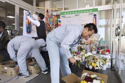 写真：斜里町役場で献花台を解体する職員ら＝２４日午前