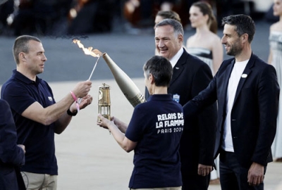 写真：パリ五輪の聖火を引き渡す式典に参加した大会組織委員会のエスタンゲ会長（右端）＝２６日、アテネ（ロイター＝共同）