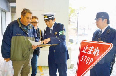 写真：訪日客へ交通標識の説明をする川瀨巡査部長
