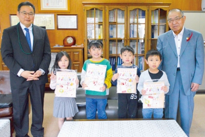 写真：集合写真に納まる子どもたちと横尾会長（右）、松田校長（左）