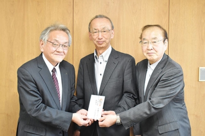 写真：國枝会長（左）に善意を手渡す右から佐藤副会長と柴原事務局長