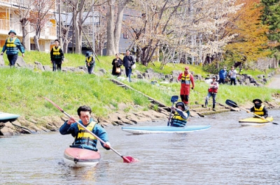 写真：知利別川でカヤックをこぐ参加者ら