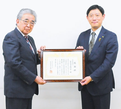 写真：青山市長から感謝状を受け取る野尻会長（左）