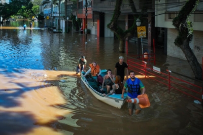 写真：洪水が起き、ボートで避難する住民ら＝７日、ブラジル・ポルトアレグレ（ゲッティ＝共同）